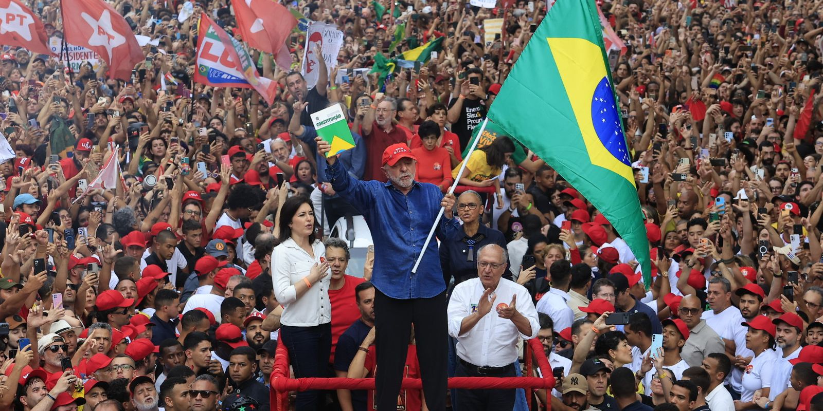 Lula com a Constituição e a bandeira em ato de campanha antes do 2º turno