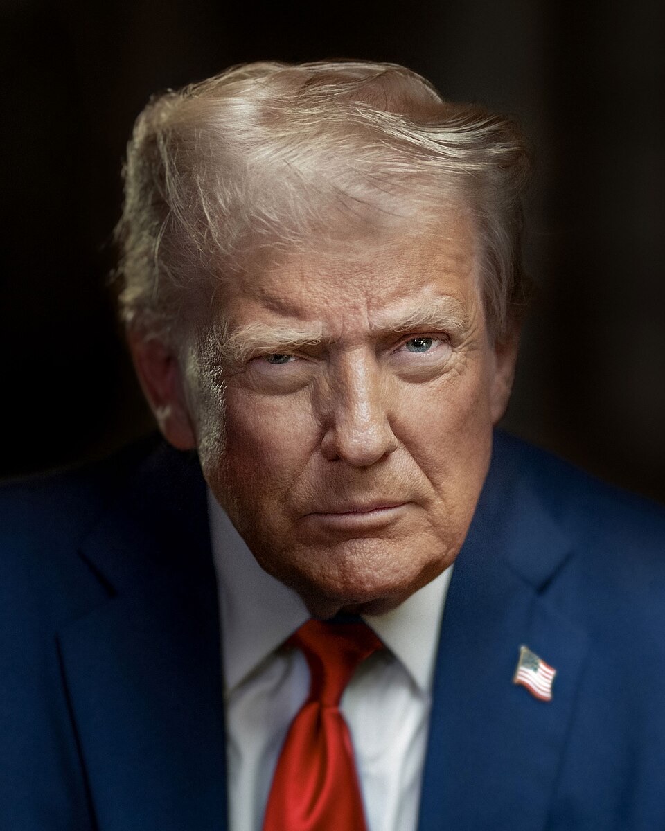 Retrato oficial de Donald Trump, de terno escuro e gravata azul, diante das bandeiras